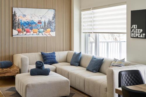 a living room with a white couch and blue pillows at Unité 104 in Beaupré
