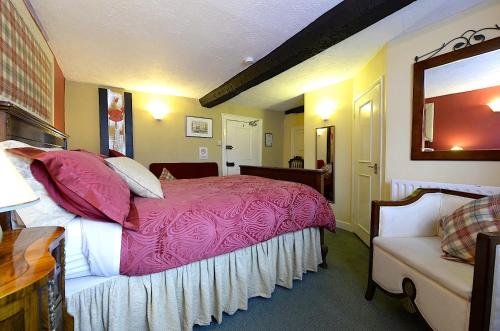 a bedroom with a pink bed and a couch at Meryan House Hotel in Taunton