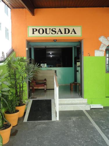 una entrada a un edificio de possada con un cartel en él en Pousada Orquidário en Santos