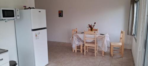 a kitchen with a table and a white refrigerator at Tamara in La Paloma
