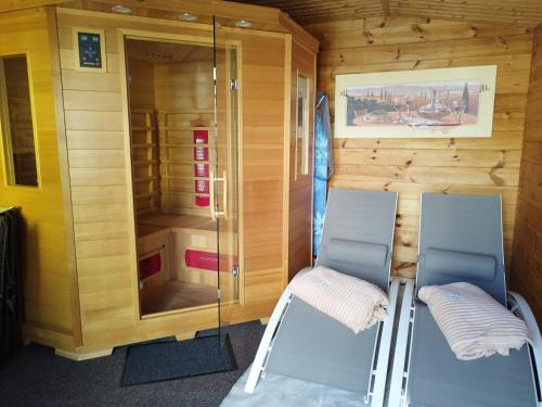 a small room with two chairs and a glass wall at "Ferienhaus-Ottendorf" mit Pool und Infarotkabine in Ottendorf