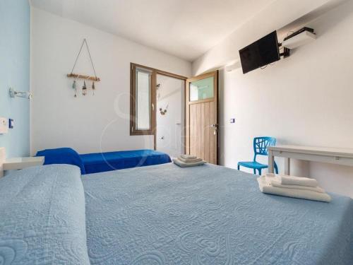 a bedroom with a blue bed and a blue chair at Maresidence Rooms & Breakfast in Torre Pali