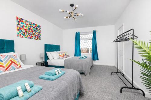 a bedroom with two beds and blue curtains at Temple by Alt-Stay Contractor Accommodation - 4 Bed Contractor Home With Parking, Wi-Fi & Full Kitchen - Ideal For Long stays in Leeds