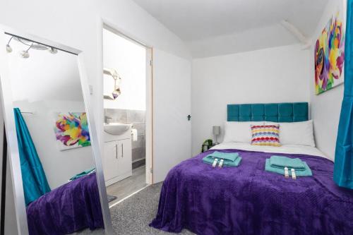 a bedroom with a purple bed and a mirror at Temple by Alt-Stay Contractor Accommodation - 4 Bed Contractor Home With Parking, Wi-Fi & Full Kitchen - Ideal For Long stays in Leeds