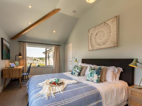a bedroom with a large bed with a table on it at 5 Bed in Fowey oc-93849 in Polruan
