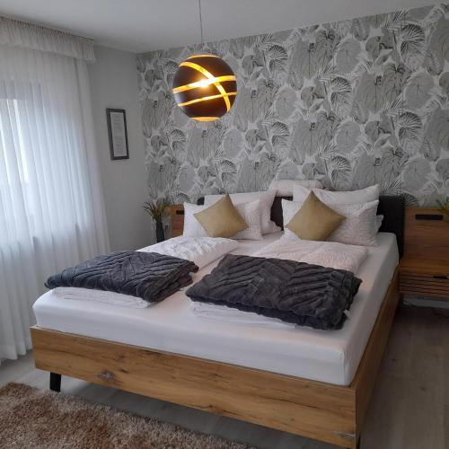 a bedroom with a large bed with white sheets at Ferienwohnung " Am Dorfbrunnen" in Dienethal