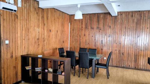 a dining room with a table and chairs and wood panels at Abrigo dos Prazeres Guesthouse by Mth in Prazeres