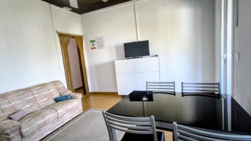 a living room with a table and chairs and a couch at Abrigo dos Prazeres Guesthouse by Mth in Prazeres