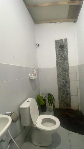a bathroom with a toilet and a sink at beaches Lyfe Rooms in Kuta Lombok