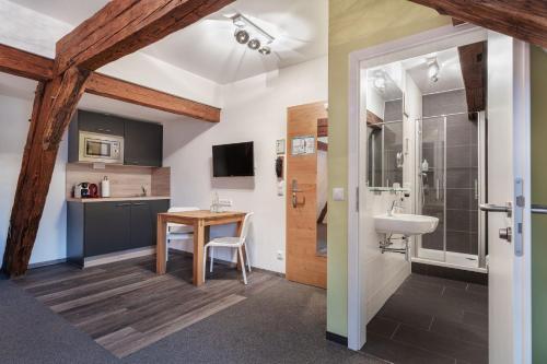 a bathroom with a sink and a toilet and a table at Schieners Hotel & Apfelhof Apartments in Wemding