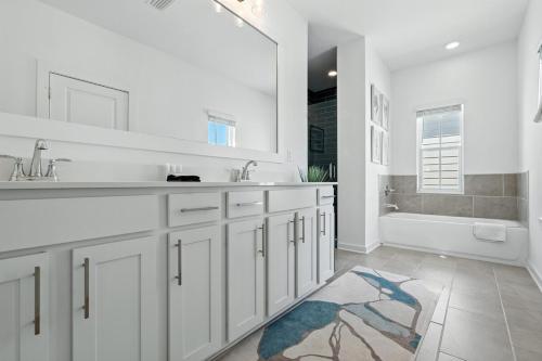 a white bathroom with a sink and a tub at Famiy and Pet friendly, close to Wharf, pool in Orange Beach