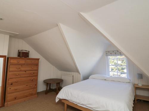 a bedroom with a bed and a dresser and a window at 36 Crowthers Hill in Dartmouth
