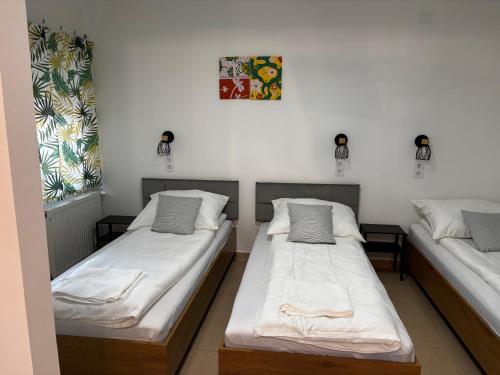 two twin beds in a room with at Maxi Apartman in Budaörs
