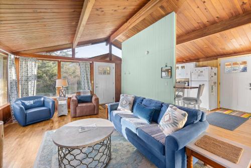 a living room with a blue couch and a table at The Lily Pad in Rockaway Beach
