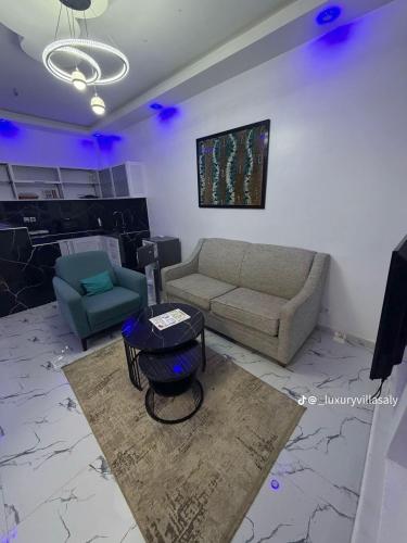 ein Wohnzimmer mit Sofa und Tisch in der Unterkunft Studio prestige in Saly Portudal