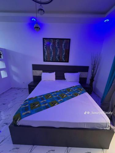 una camera da letto con un letto grande con illuminazione viola di Studio prestige a Saly Portudal