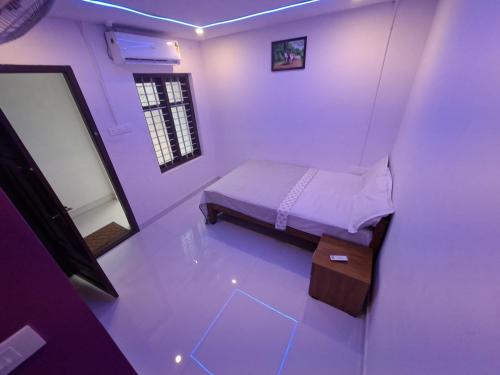 a small bedroom with a bed and a mirror at Dolphin beach resort in Varkala