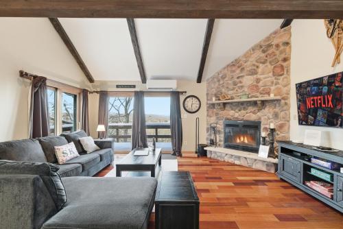 a living room with a couch and a fireplace at Cozy Camelback, Pocono Retreat with Mountain Views! in Tannersville