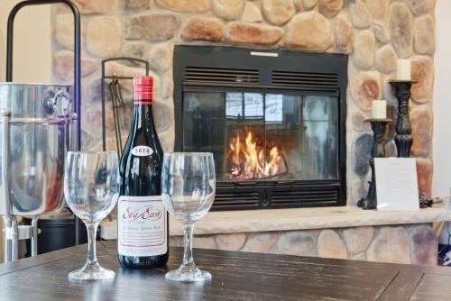a bottle of wine sitting on a table with two wine glasses at Cozy Camelback, Pocono Retreat with Mountain Views! in Tannersville