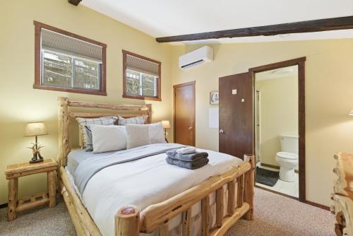 a bedroom with a wooden bed and a toilet at Cozy Camelback, Pocono Retreat with Mountain Views! in Tannersville