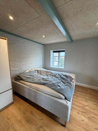 a bed in a room with a brick wall at AE323-Soby-Aero-Sondervejen-5 in Søby