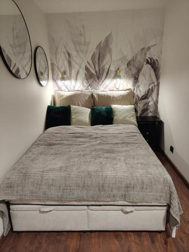 a bedroom with a large bed with two mirrors on the wall at Studio 27 in Zabrze