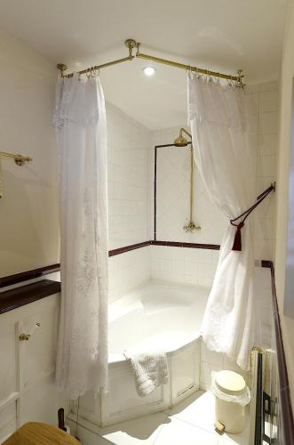 a white bath tub in a bathroom with a toilet at Meryan House Hotel in Taunton