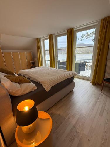 a bedroom with a bed and a table with a lamp at Viktoria`s Penthouse in Bad Breisig