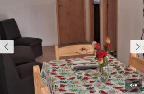 a living room with a table with a vase of flowers at Rodolfo in La Paloma