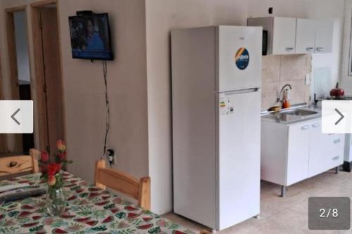 a kitchen with a white refrigerator and a table at Rodolfo in La Paloma