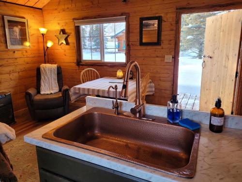 a kitchen with a sink in a log cabin at Little Bear Getaway Cabins in Glacier View