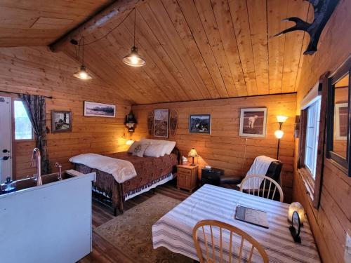 a bedroom with two beds and a kitchen in a cabin at Little Bear Getaway Cabins in Glacier View