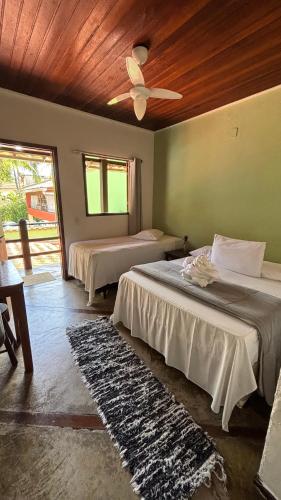 a bedroom with two beds and a ceiling at Pousada Lua Nova in Paraty