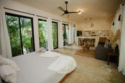 a bedroom with a white bed and a living room at El Valle Villas in Santa Bárbara de Samaná