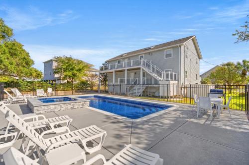 a house with a swimming pool and some chairs at Long Bay Duplex in Myrtle Beach