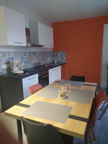 a kitchen with a wooden table with chairs and a kitchen at duplex neuf autonome in Broyes