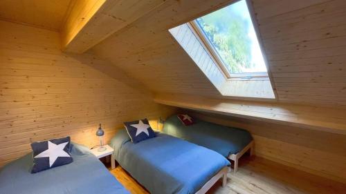 two beds in a attic room with a window at Chalet Serra 1506 Geopark S Estrela in Penhas da Saúde