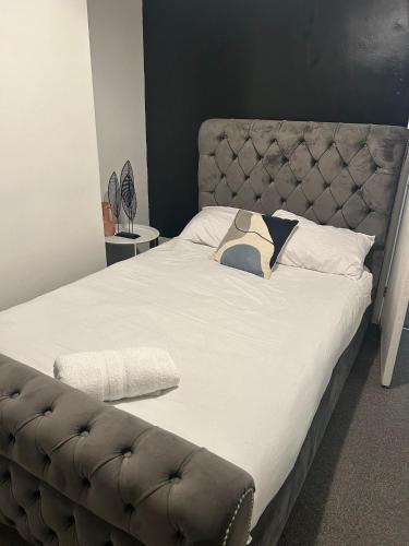 a bedroom with a large bed with a leather headboard at Spacious 3 bedroom home, sleeps 8, Parking, Central Rochester in Rochester