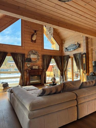 a large couch in a living room with windows at Rezidencia Woodchalet in Veľká Lomnica