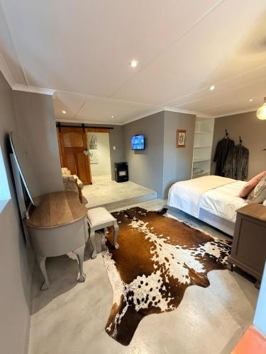 a bedroom with a bed and a desk and a tub at Uys Cottage on 79 in Heidelberg