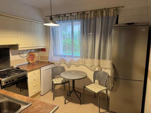 a kitchen with a table and chairs and a refrigerator at Varandas do Funchal in Funchal