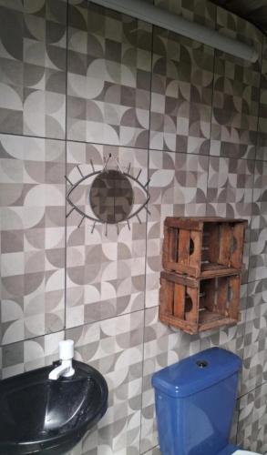 a bathroom with a black sink and a blue toilet at Kombi Home in Piedade