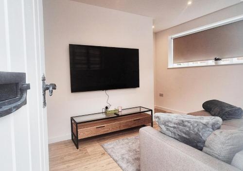 a living room with a couch and a flat screen tv at Cosy & Luxury 2BR Flat in Calverton in Calverton