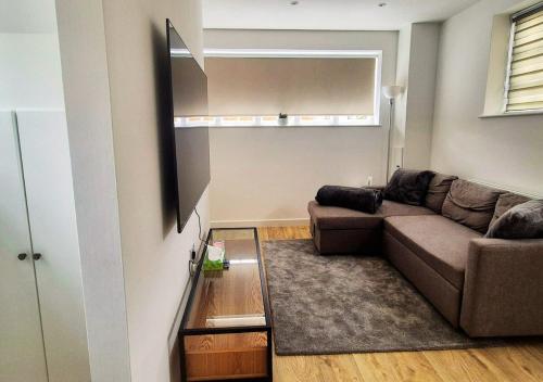 a living room with a couch and a mirror at Cosy & Luxury 2BR Flat in Calverton in Calverton