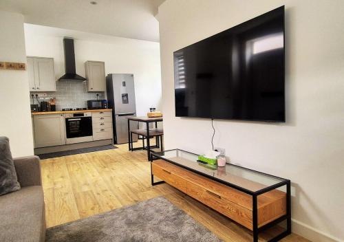a living room with a large flat screen tv on the wall at Cosy & Luxury 2BR Flat in Calverton in Calverton