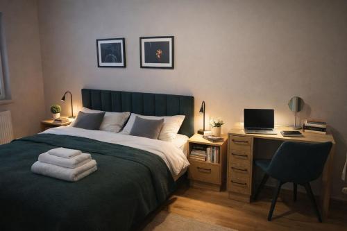 a bedroom with a bed and a desk with a computer at APART FLOW Walendów Park in Nadarzyn
