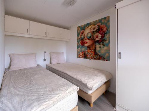 a bedroom with two beds and a painting on the wall at Ermmoon Cottage in Erm