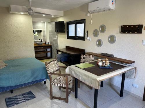 a room with a table and a bed and a kitchen at Departamento para 2 pers con vista a las sierras OC in Villa Giardino