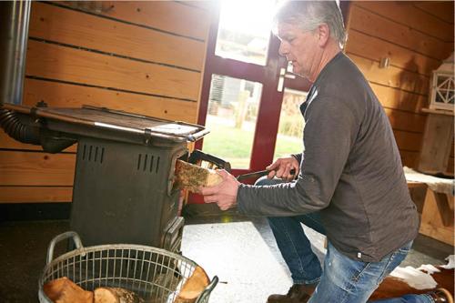 OeneにあるDromen bij de boerの男が食べ物を焼き上げている