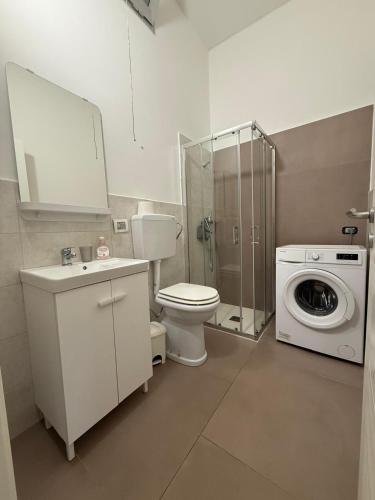 a bathroom with a toilet and a washing machine at casa surano in Diso